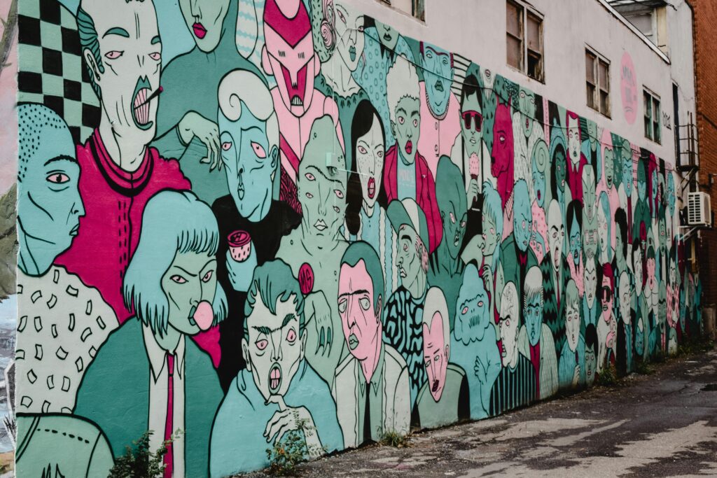 Colorful street art mural showcasing diverse faces in a Montreal alleyway. How to paint a mural