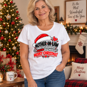 Woman wearing a Mother-in-Law Christmas T-shirt featuring “Family by Marriage, Friend by Choice” with festive Santa hat artwork.