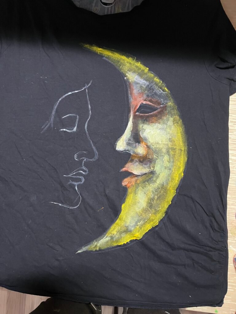 Early hand-painted black fabric experiment with colorful crescent moon face