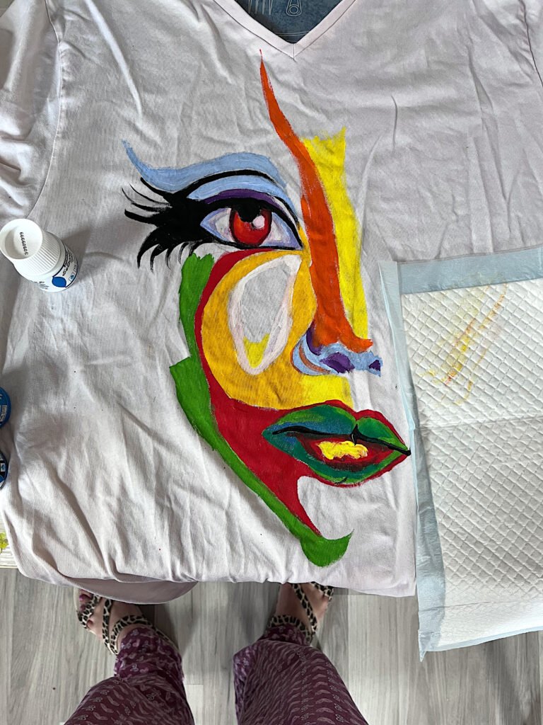 Early hand-painted clothing experiment with colorful abstract face