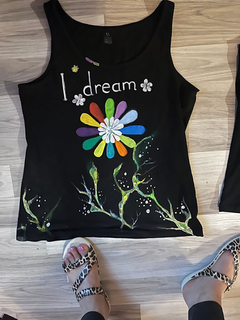 Hand-painted black T-shirt with colorful flower and dream lettering
